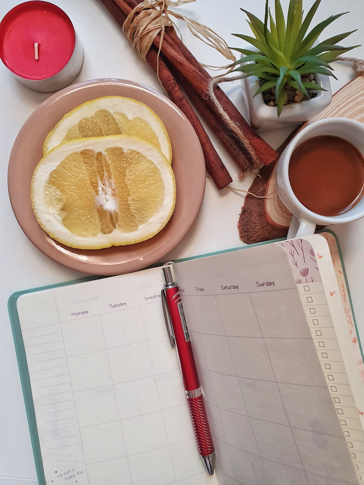 Planner, coffee and candle on a table